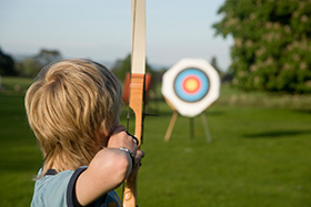 Archery boy aims at target